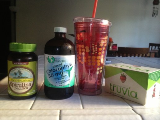 spirulina powder, mint-flavored chlorophyll, a 20-oz cup of water with a straw, and a stevia sweetener. 